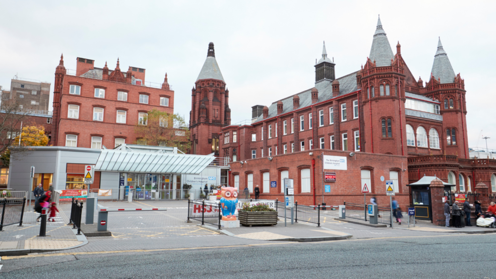 Fire safety advisors consulting outside historic red brick building in city centre.
