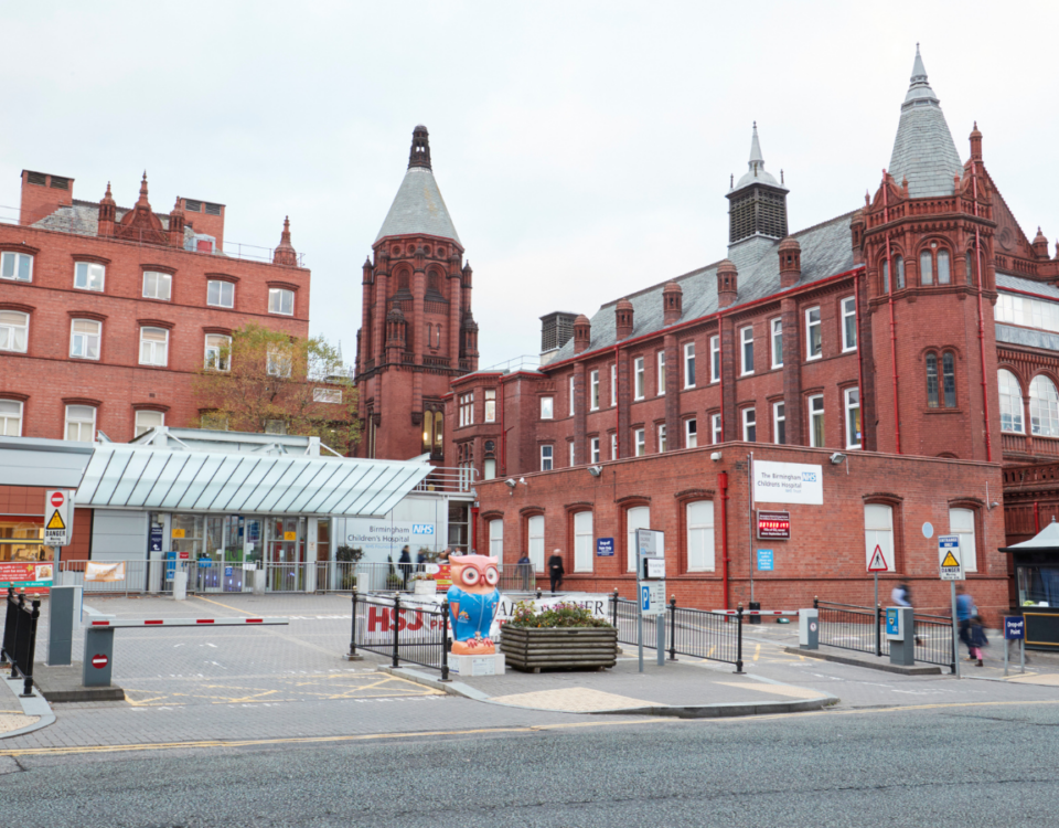 Fire safety advisors consulting outside historic red brick building in city centre.