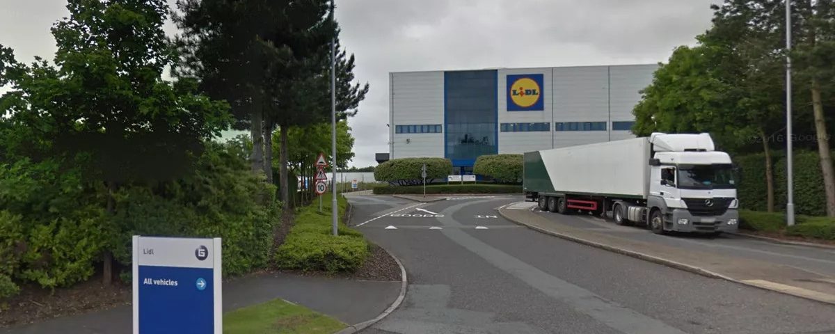 Fire safety advisory sign near Lidl store with a truck on the road, emphasizing fire safety regulati.